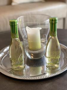 two glass bottles on a silver tray with a candle at Meeresbrise in Scharbeutz