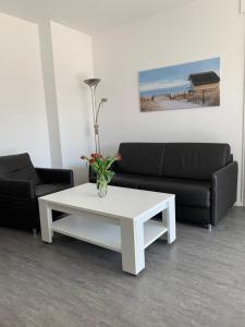 uma sala de estar com um sofá e uma mesa de café branca em Bellevue Nr. 35 em Scharbeutz