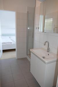 uma casa de banho branca com um lavatório e um chuveiro em Bellevue Nr. 35 em Scharbeutz