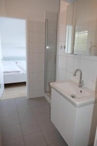 a white bathroom with a sink and a shower at Bellevue Nr. 35 in Scharbeutz