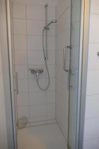 uma casa de banho com um chuveiro e uma porta de vidro em Bellevue Nr. 35 em Scharbeutz