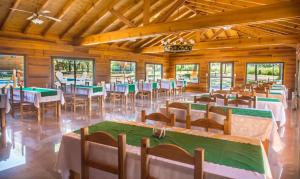 un salón de banquetes con mesas y sillas. en Del Milagro Cabañas & Posada en Villa General Belgrano