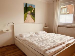 Bett in einem Schlafzimmer mit Wandgemälde in der Unterkunft Turmresidenz App. 3 in Scharbeutz