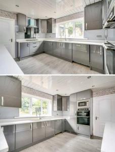 uma grande cozinha com armários brancos e electrodomésticos de prata em Frank lane em Dewsbury