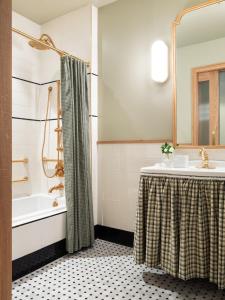 a bathroom with a shower and a sink and a tub at Palihouse Hyde Park Village in Tampa