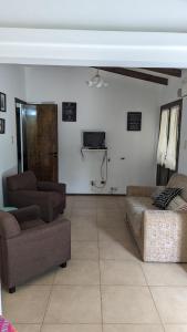 sala de estar con sofás, sofá y TV en Besares en Luján de Cuyo