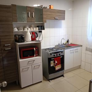 a small kitchen with a stove and a microwave at Casa dos dormitorios in Iquique