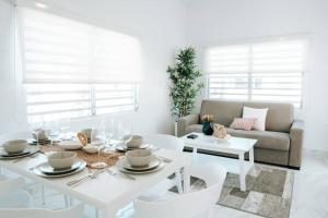 聖胡安的住宿－Casita Style Apt 3 w/ Sofa Bed & Patio @ Santurce，白色的客厅配有白色的桌子和椅子