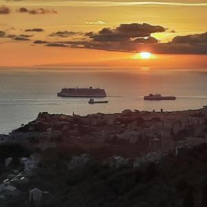 a sunset over a city with a ship in the water at Dal Moro 44 