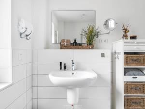 a white bathroom with a sink and a mirror at Ferienwohnung Ostseebrise Damp in Damp +21 photos