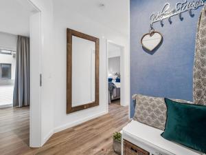 sala de estar con espejo y sofá en Ferienwohnung AusZeit 24 7, en Damp