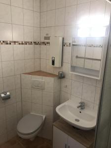 a small bathroom with a toilet and a sink at Ferienwohnung StrandinSicht in Damp