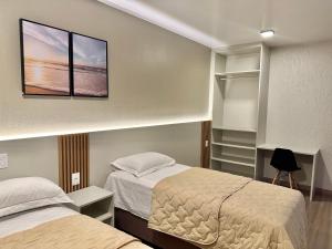 a small bedroom with two beds and a closet at Pousada Marebotto in Capão da Canoa +44 photos