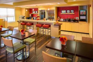 TownePlace Suites New Orleans Metairie في Harahan: مطعم بطاولات وكراسي ومطبخ