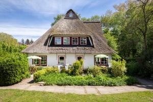 an old house with a thatched roof at Kutscherhaus - Kutscher Karl in Manhagen