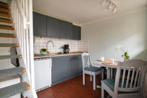 a small kitchen with a small table and chairs at Kutscherhaus - Kutscher Karl in Manhagen