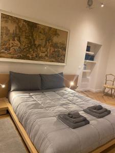a bedroom with a large bed with a large painting on the wall at sonnino house in Pisa