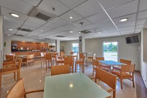 un restaurant avec des tables, des chaises et un comptoir dans l'établissement City Express by Marriott Mazatlan, à Mazatlán