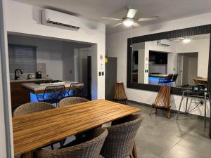 Una cocina y un comedor con mesa y sillas de madera. en Departamento en 1er piso 2 bdr 2bath tezal, en Cabo San Lucas