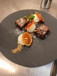 Hotel Restaurant Croix Blanche في Sugiez: صحن أسود مع طعام على طاولة