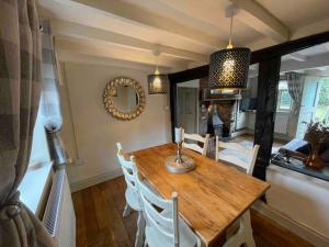 ein Esszimmer mit Tisch und Stühlen und einem Spiegel in der Unterkunft Ty Twty, Montgomery Cottage in Montgomery