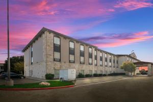 un grand bâtiment avec un camion garé dans un parking dans l'établissement Comfort Suites, à Granbury