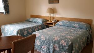 a hotel room with two beds and a table at Mountain View Motel in Smithers +38 photos