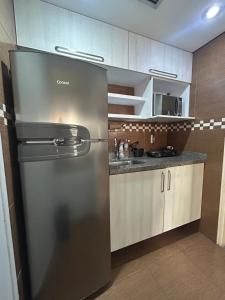 a kitchen with a stainless steel refrigerator in a kitchen at QI Intelligence Flat in Sao Paulo