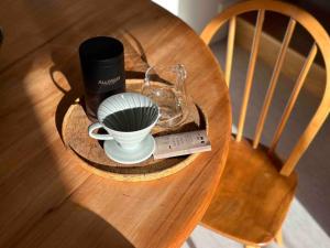 a wooden table with a cup and a coffee maker on it at The Driving Creek Cottage in Coromandel Town