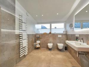a bathroom with a sink and a tub and a toilet at Fewo Sterntaler DG mit Bergblick in Garmisch-Partenkirchen