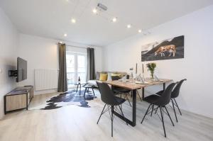 a dining room and living room with a table and chairs at Enzian Apartments in Grainau