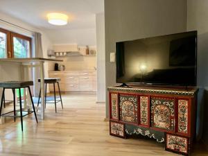 una sala de estar con TV de pantalla plana en una cómoda en Alpenlodge am Waldrand in Grainau en Grainau