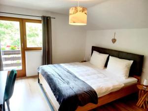 1 dormitorio con cama y ventana grande en Alpenlodge am Waldrand in Grainau en Grainau