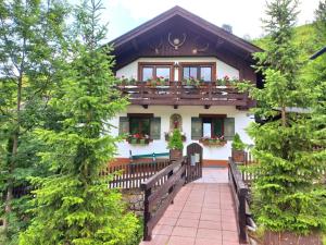 Jägerlodge am Waldrand in Grainau في غرينو: منزل مع شرفة عليها زهور