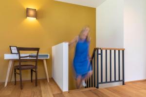 a woman in a blue dress is walking down the stairs at Ferienwohnungen Friedenshöhe in Oberammergau in Oberammergau