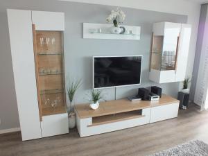 a living room with a tv and a white entertainment center at Watten-Blick 2 in Cuxhaven