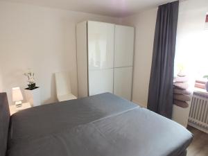 ein Schlafzimmer mit einem Bett und einem weißen Schrank in der Unterkunft Watten-Blick 2 in Cuxhaven