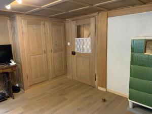 Habitación vacía con puertas de madera y TV. en Revier mitenand im Gand en Rüti