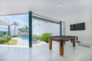 a ping pong table in a room with a view of a pool at Hotel Nacional Inn Cuiabá in Cuiabá