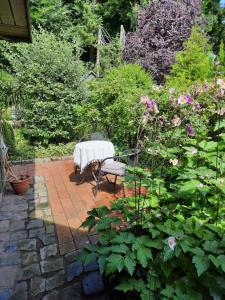 un giardino con tavolo, panca e fiori di Waldblick a Ratekau