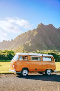 un furgone arancione parcheggiato sul lato di una strada di Hawaii Surf Campers a Wahiawa