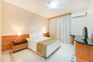 a hotel room with a bed and a flat screen tv at Hotel Nacional Inn Cuiabá in Cuiabá +22 photos