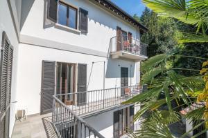ein weißes Haus mit Balkonen und Palmen in der Unterkunft Villa Orta in Orta San Giulio