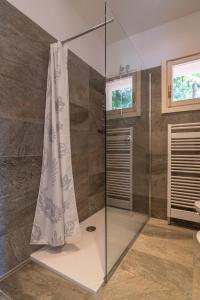 La salle de bains est pourvue d'une douche et d'un rideau de douche. dans l'établissement Villa Orta, à Orta San Giulio