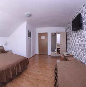 Habitación de hotel con 2 camas y TV de pantalla plana. en Pensiunea Gaby, en Cluj-Napoca