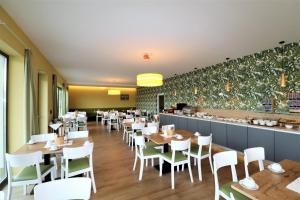 um restaurante com mesas e cadeiras brancas e um bar em Wreecher Idyll 27 Komfortables Appartement mit Terrasse und Garten em Putbus