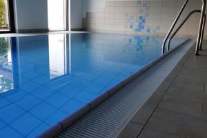 uma piscina vazia com azulejos azuis no chão em Wreecher Idyll 27 Komfortables Appartement mit Terrasse und Garten em Putbus
