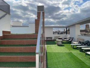 a patio with grass and stairs on a building at Casa Yaye Écija in Écija