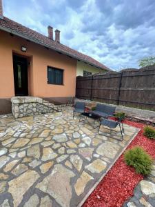 a patio with two chairs and a table in front of a house at Apartman Alibi in Boljevac