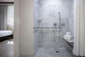 uma casa de banho com um chuveiro e uma porta de vidro em Winter Haven Hotel, Miami Beach, Autograph Collection em Miami Beach